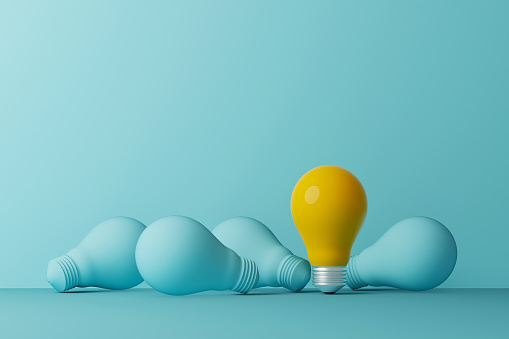 Light bulb yellow outstanding among lightbulb light blue on same color background. Concept of creative idea and innovation, Unique, Think different, standing out from the crowd. 3d illustration