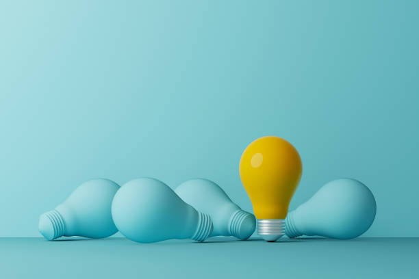 Light bulb yellow outstanding among lightbulb light blue on same color background. Concept of creative idea and innovation, Unique, Think different, Individual and standing out from the crowd. 3d illustration stock photo