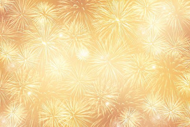 легкий золотой праздничный фон с большим количеством фейерверков - happy new year стоковые фото и изображения