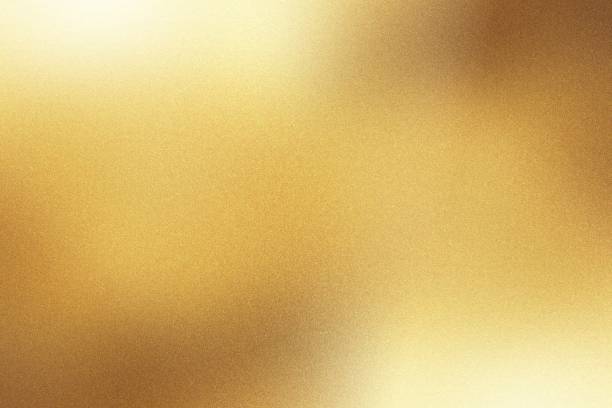 Photo of Light shining down on gold foil metal wall with copy space, abstract background