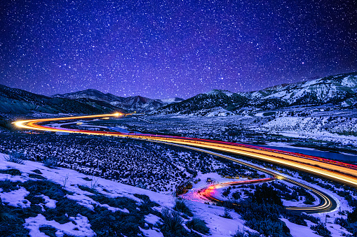 Light Trails at Night I70 Colorado - Highway running through valley at night under starry skies with light trails from vehicles driving along Interstate 70  east of Glenwood Canyon looking toward Gypsum, Eagle, Wolcott, Edwards and Vail, Colorado USA.