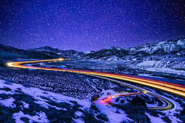 Light Trails at Night I70 Colorado Light Trails at Night I70 Colorado - Highway running through valley at night under starry skies with light trails from vehicles driving along Interstate 70  east of Glenwood Canyon looking toward Gypsum, Eagle, Wolcott, Edwards and Vail, Colorado USA. blue hour twilight stock pictures, royalty-free photos & images