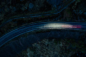 Light trails in the night on a remote road in mountains, Highlands, Scotland, UK.