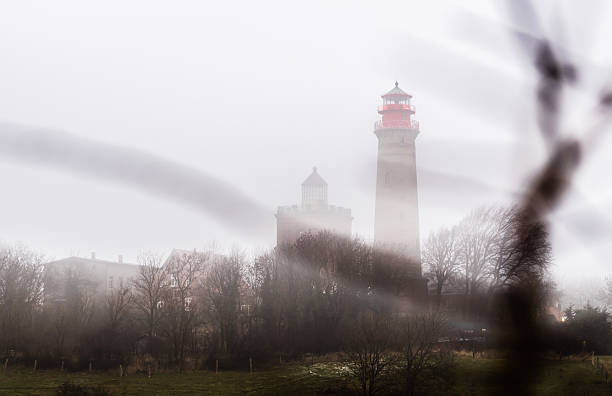Lighthouse in fog mist and clouds Lighthouse in fog mist and clouds at island of ruegen germany r��gen stock pictures, royalty-free photos & images