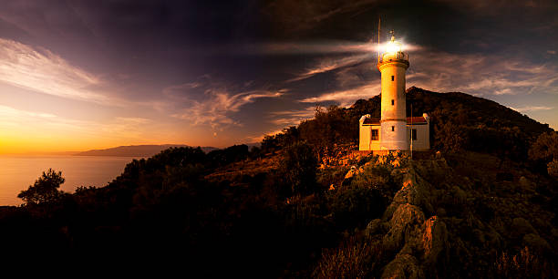 Lighthouse shining at twilight stock photo