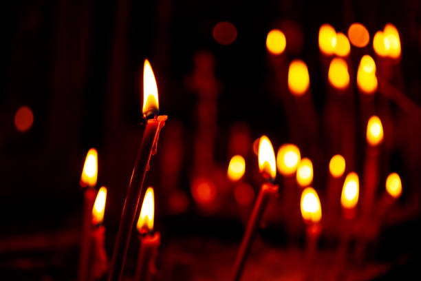 Lighting candles inside dark room stock photo