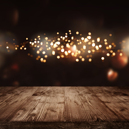 Festive golden lights in dark background and empty wooden stage for a christmas concept