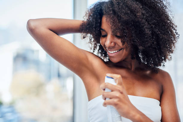 I like to look fresh and smell it too! Shot of a woman spraying deodorant on her underarms deodorant stock pictures, royalty-free photos & images