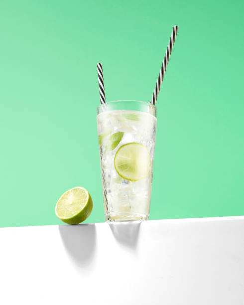 Lime Juice with Ice Cubes and Reusable Drinking Straws Lime Juice with Ice Cubes highball glass stock pictures, royalty-free photos & images