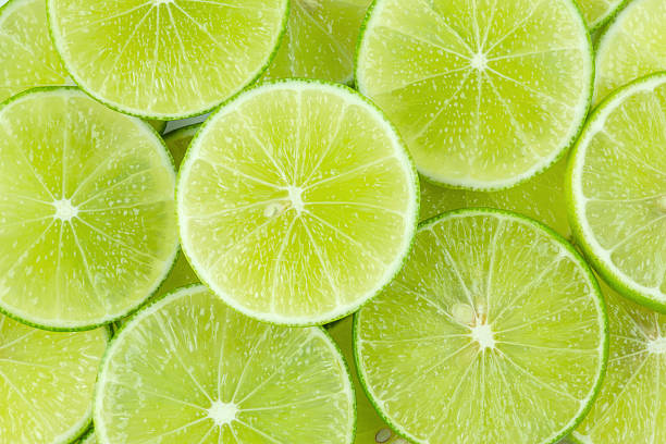 lime fresh green lime sliced background lime stock pictures, royalty-free photos & images