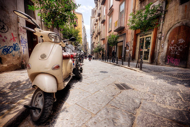 line of vespas on an italian street in the summer - napoli stockfoto's en -beelden