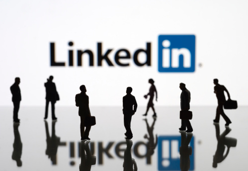 İstanbul, Turkey - February 12, 2014: Human figurines standing in front of Apple iPad monitor displaying LinkedIn logo. LinkedIn is a social networking service for people in professional occupations.