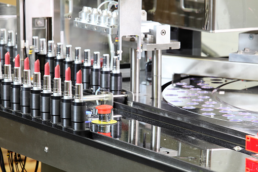 A lipstick packaging machine in a cosmetics factory.