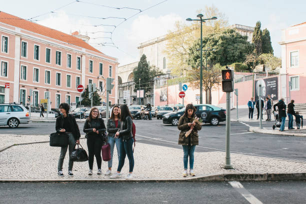 lisbon, portugal 01 may 2018: pedestrians cross street. girls or company of friends stand on intersection. - taxi lisboa imagens e fotografias de stock