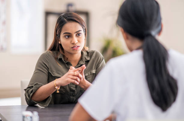 Listening To The Counselor A frustrated woman is chatting with her mental health doctor. She is giving her some advice on how to deal with the complexities of life. mental health awareness stock pictures, royalty-free photos & images