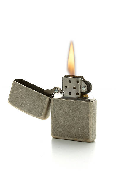 A lit cigarette lighter with the gray top folded open stock photo
