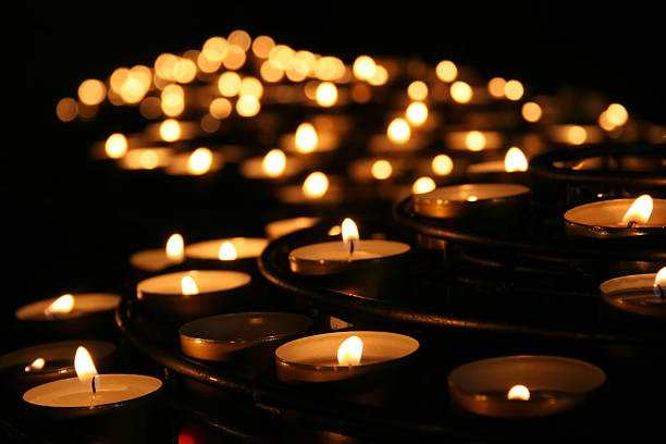 Lit praying candles in a temple stock photo