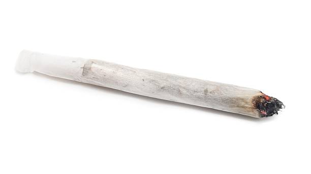 Lit self-made joint on a white background Burning marijuana joint isolated on white background. marijuana joint stock pictures, royalty-free photos & images