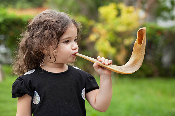 Little girl blowing shofar for Rosh Hashana