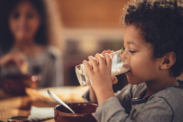 Little African American boy drinking fresh milk from a glass. Small black boy drinking fresh milk during breakfast. drinking milk stock pictures, royalty-free photos & images