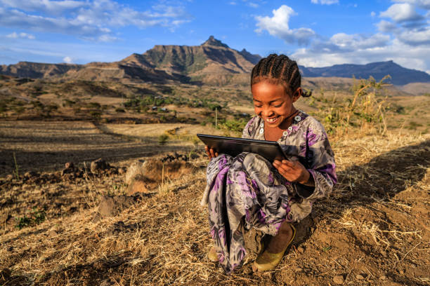 Little African girl is using digital tablet, East Africa stock photo