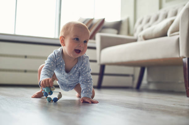 little baby boy crawling on floor at home stock photo