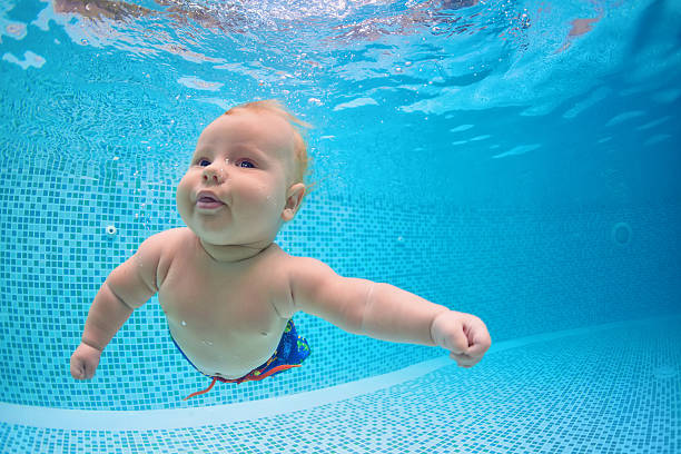 little baby dive underwater with fun in swimming pool - swimming baby stockfoto's en -beelden