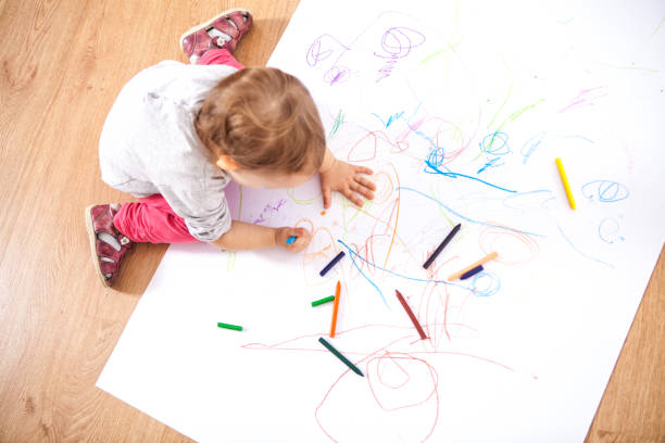 Little baby girl drawing stock photo