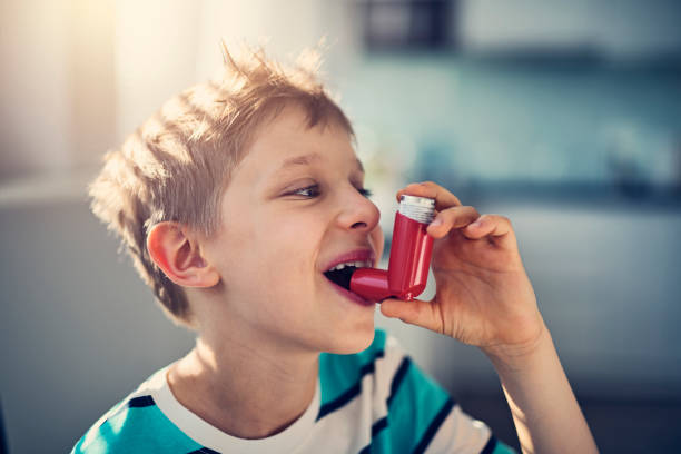 kleiner junge und seine asthma-inhalator - asthmainhalator stock-fotos und bilder