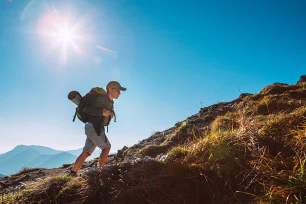 Little Boy backpacker traveler walking up on mountain top in High Tatra mountains Little Boy backpacker traveler walking up on mountain top in High Tatra mountains scout camp stock pictures, royalty-free photos & images