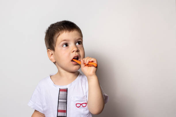 Little boy brushes his teeth with baby toothpaste. Care of the oral cavity in childhood, caries of milk teeth Children's toothbrush.. swallowing toothpaste stock pictures, royalty-free photos & images