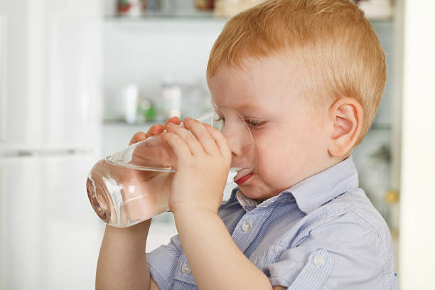 Little boy drinks water stock photo