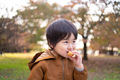 公共の公園でドーナツを食べる少年
