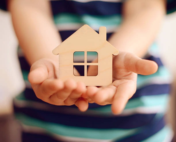 little boy holds in hands small toy house little boy holds in hands small toy house home insurance stock pictures, royalty-free photos & images