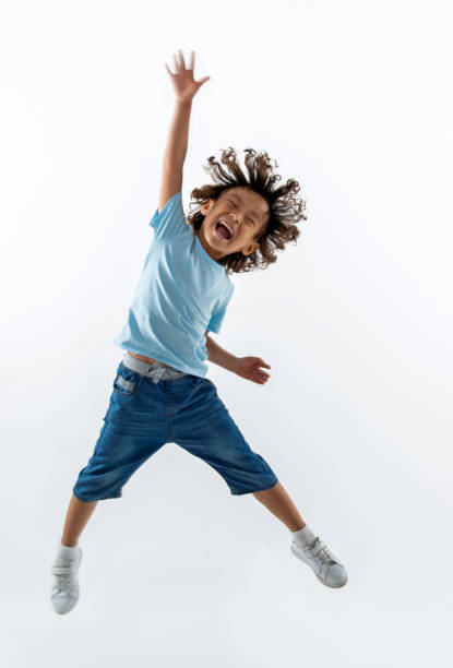Little boy jumping on white background stock photo