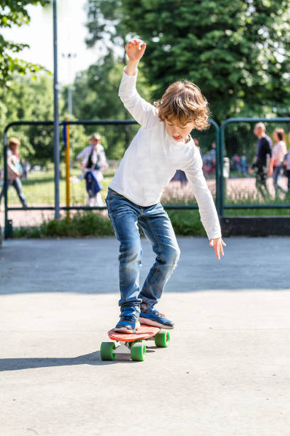 bambino (6 anni) che impara lo skateboarding - pride milano foto e immagini stock