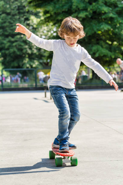 bambino (6 anni) che impara lo skateboarding - pride milano foto e immagini stock