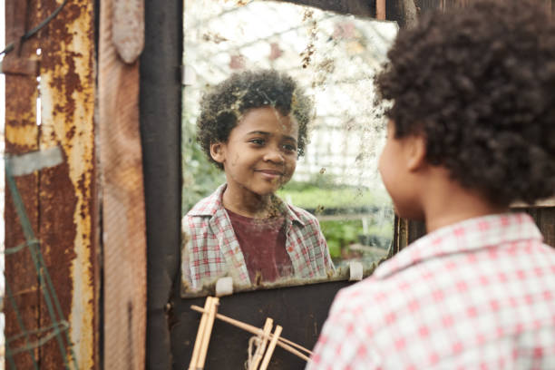 Little boy looking at mirror stock photo