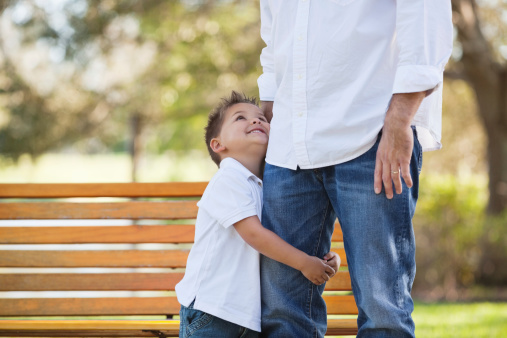 little-boy-looking-up-at-father-in-park-