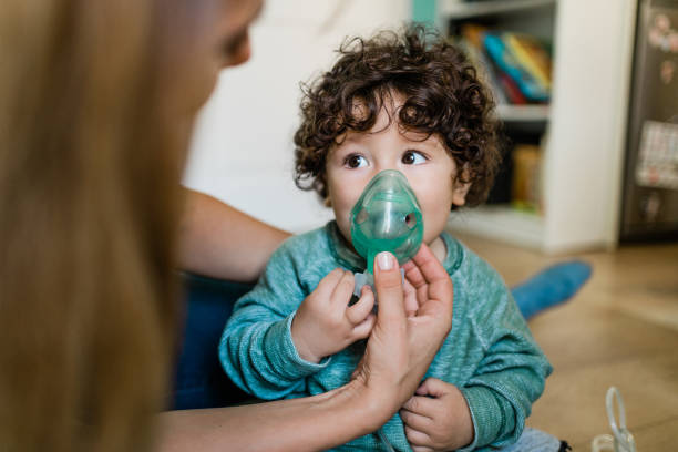 Little boy makes inhalation at home. stock photo