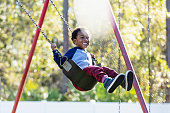 istock Little boy on playground swing 1311824608