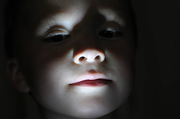 Little boy portrait in the dark making horror Little boy portrait in the dark lighted from the bottom ghost boy stock pictures, royalty-free photos & images