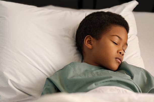 little boy sleeping in the hospital stock photo