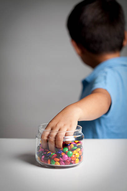 Little boy taking candy from jar Little boy secretly taking a fistful of candy from the candy jar. You may also like: candy jar stock pictures, royalty-free photos & images