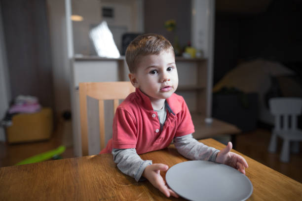 Little boy waiting for his dinner stock photo