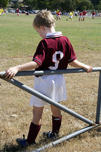 Little boy waiting in reserve to play in soccer game stock photo