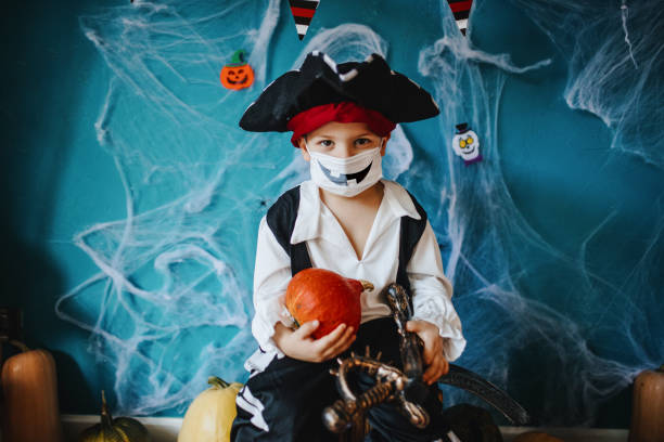 garotinho usando fantasia de halloween e máscara facial protetora durante a pandemia covid-19 - máscara covid - fotografias e filmes do acervo