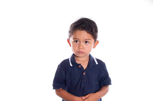 Little boy with look of sadness and regret, isolated on white background. Latin child afraid of being punished. Being reprimanded.