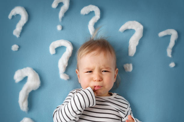little boy with lots of question marks stock photo