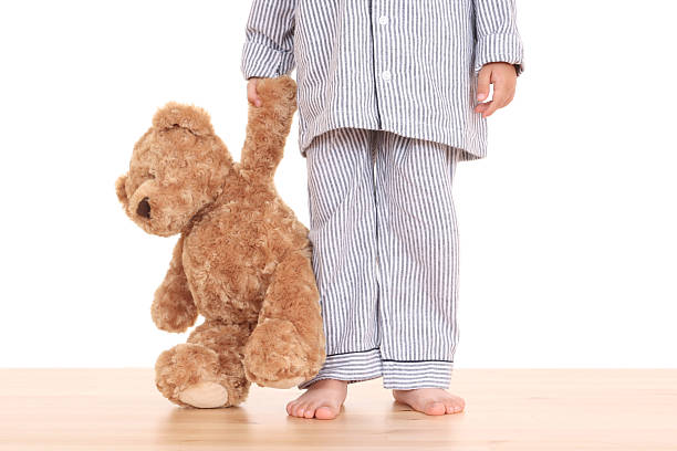 Little boy with teddy bear trying not to go to bed stock photo